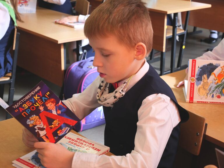 A first grader reads a certificate that he has read the ABC book. Petrozavodsk, 2021.