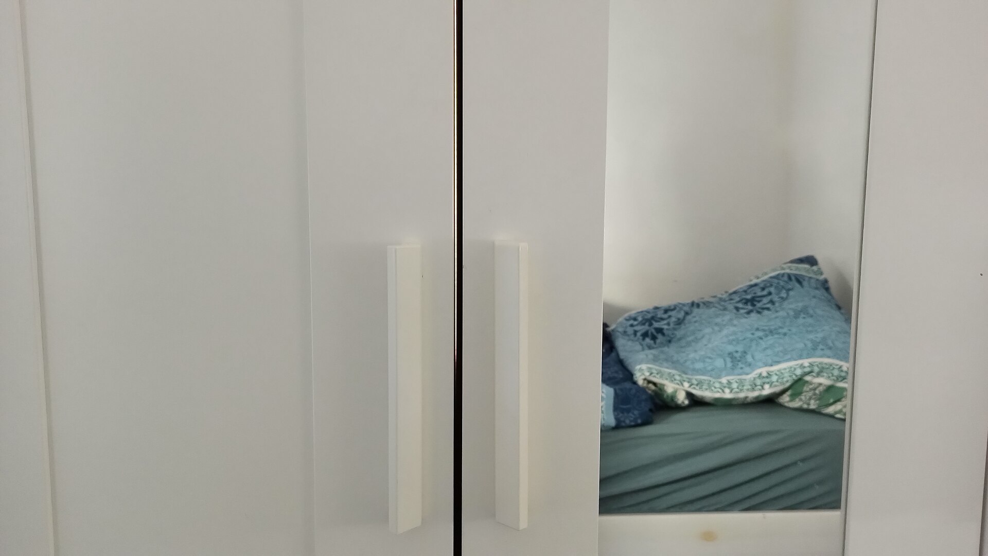 The wardrobe is placed infront of a window at daylight. While the gap on its back side is presumably unintentional, it makes up for a nice-looking lighting effect.