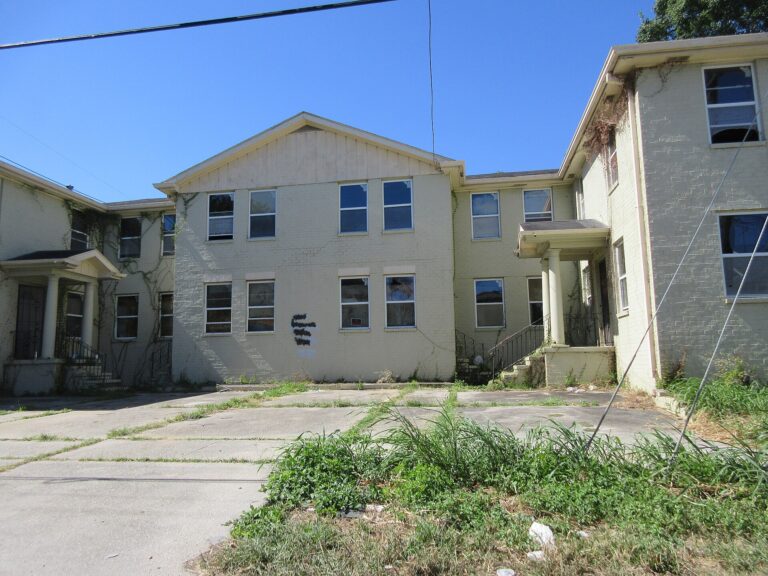 New Orleans apartment building at uptown lake corner of Dante Street & Claiborne Avenue, New Orleans, September 2022. Has graffiti on it, looks partially or all derelict.
